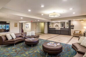 Relax in our inviting lobby with a comfortable seating area, reception desk, and large window offering a view of the outside.