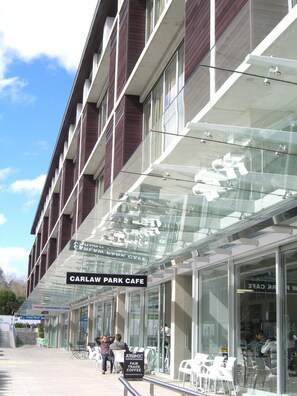 A modern building with a glass facade, labeled "CARLAW PARK CAFE" and "CARLAW CONVENIENCE STORE". - Quest Carlaw Park (Auckland)