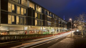 A multi-story hotel with a modern facade, large windows, and a well-lit exterior. - Quest Carlaw Park (Auckland)