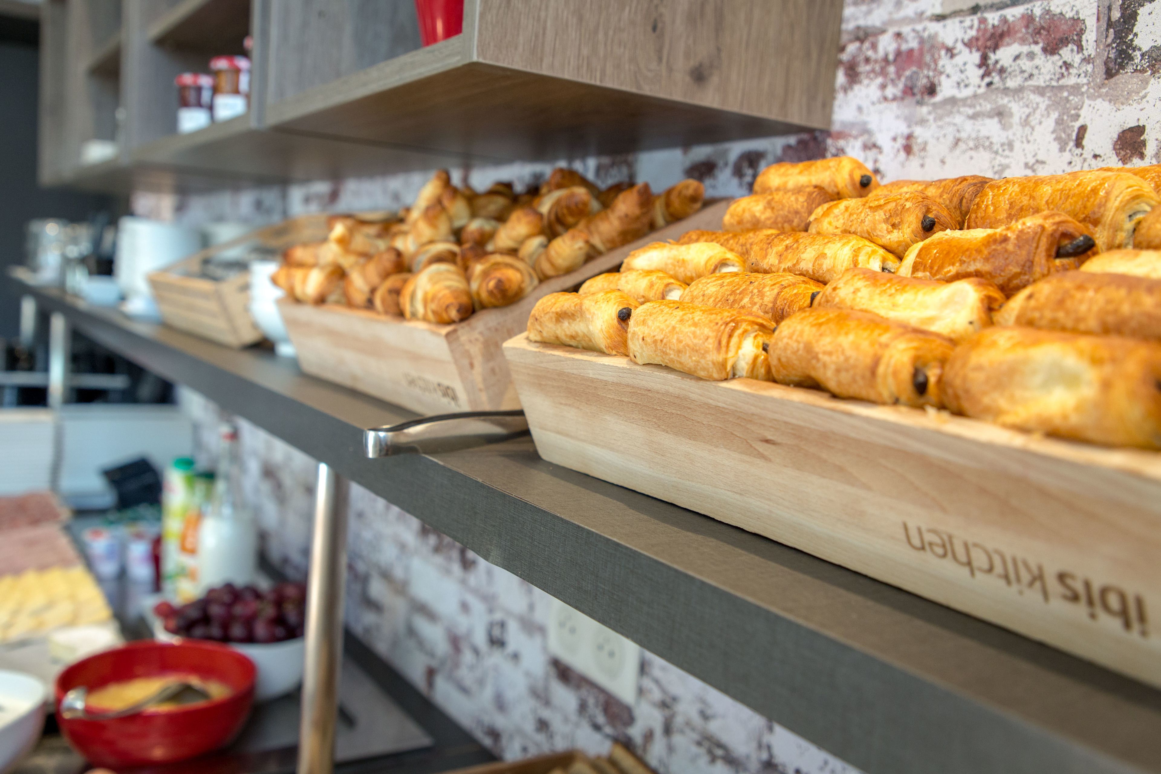 A bakery display with various pastries and a wooden cutting board labeled "Biscuits Kitchen".
