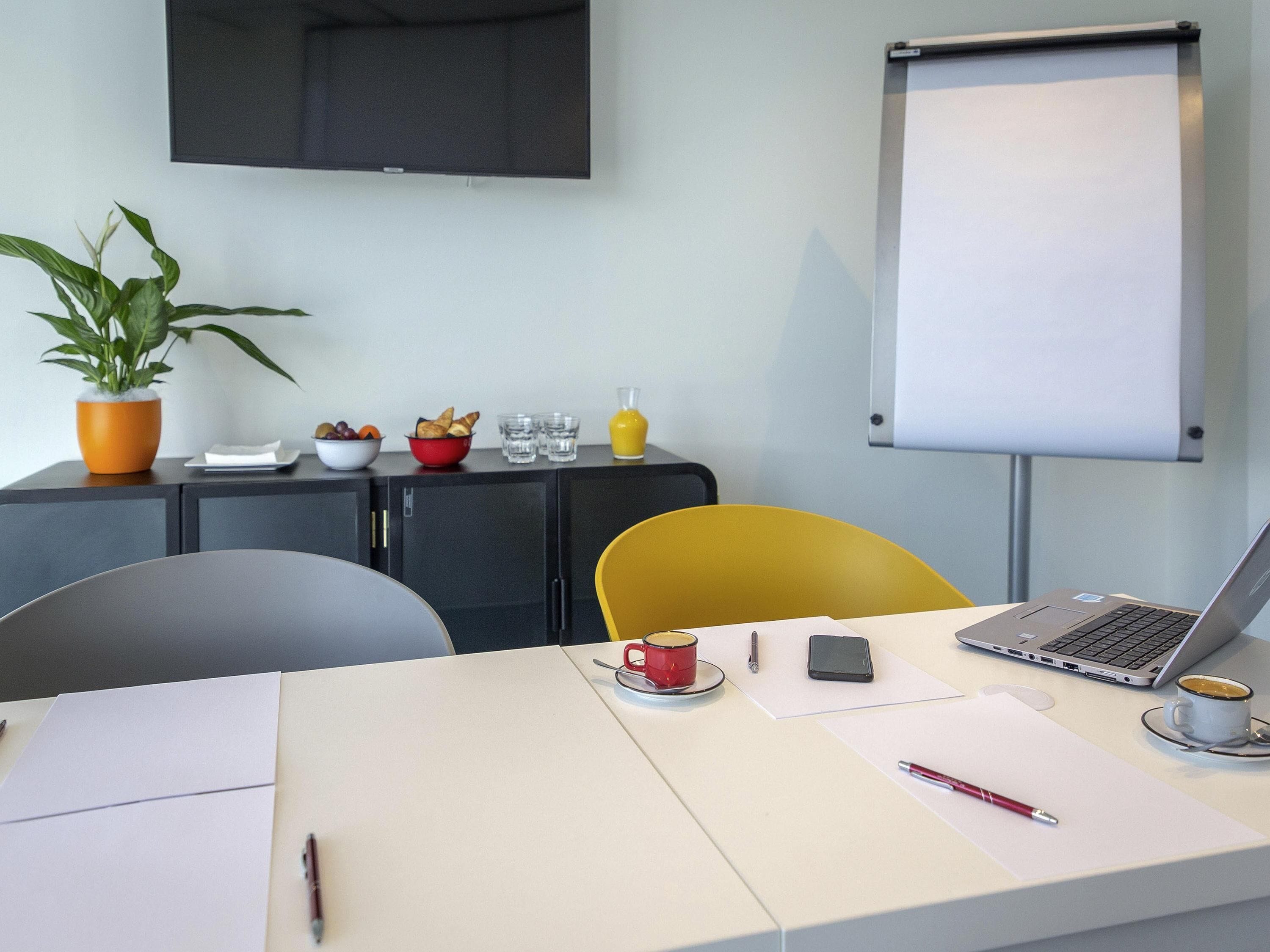 Et moderne kontor med et skrivebord, en bærbar computer og en whiteboardtavle.