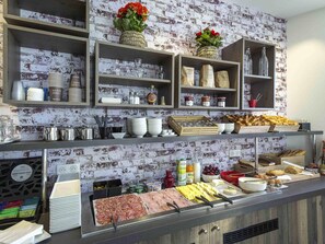 Ein reichhaltiges Buffet mit verschiedenen Speisen, Besteck und Beilagen.