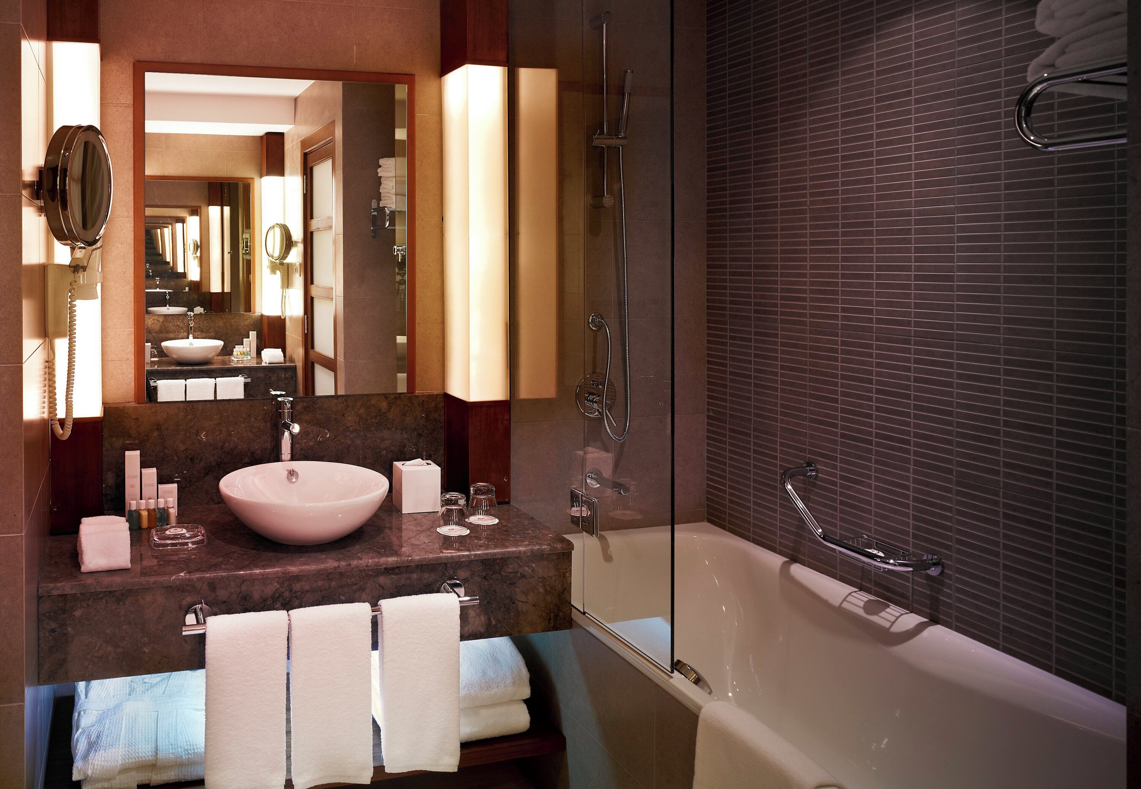 Une salle de bain moderne avec une grande baignoire, un meuble-lavabo et un miroir.