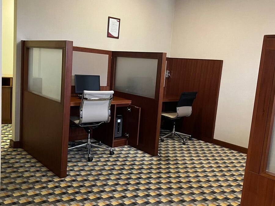 Ein Zimmer mit Schachbrettmuster-Boden, Holzwänden und Bürostühlen.