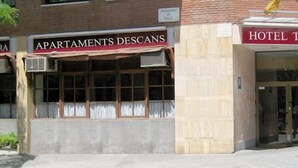A hotel named 'Hotel Traversera' with a sign for 'Apartments Descans' and a visible entrance. - Travessera Parc Guell Apartamentos (Barcelona)