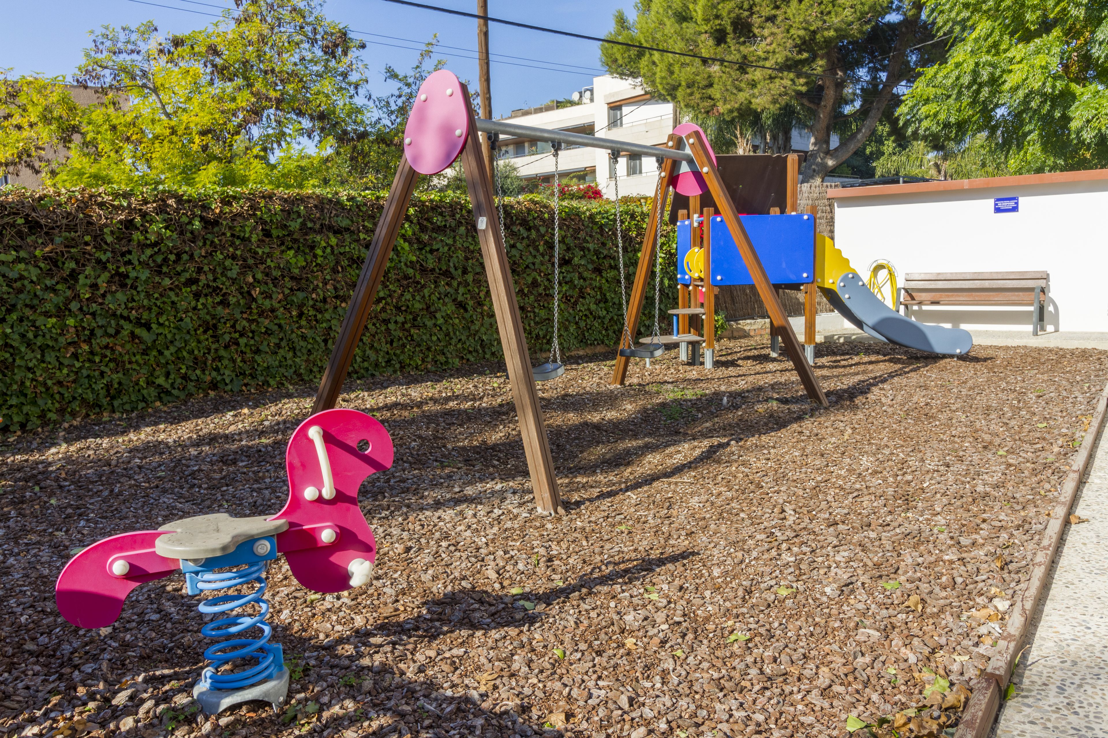 Un parque infantil con un columpio y un tobogán.