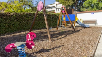 Un parque infantil con un columpio y un tobogán.