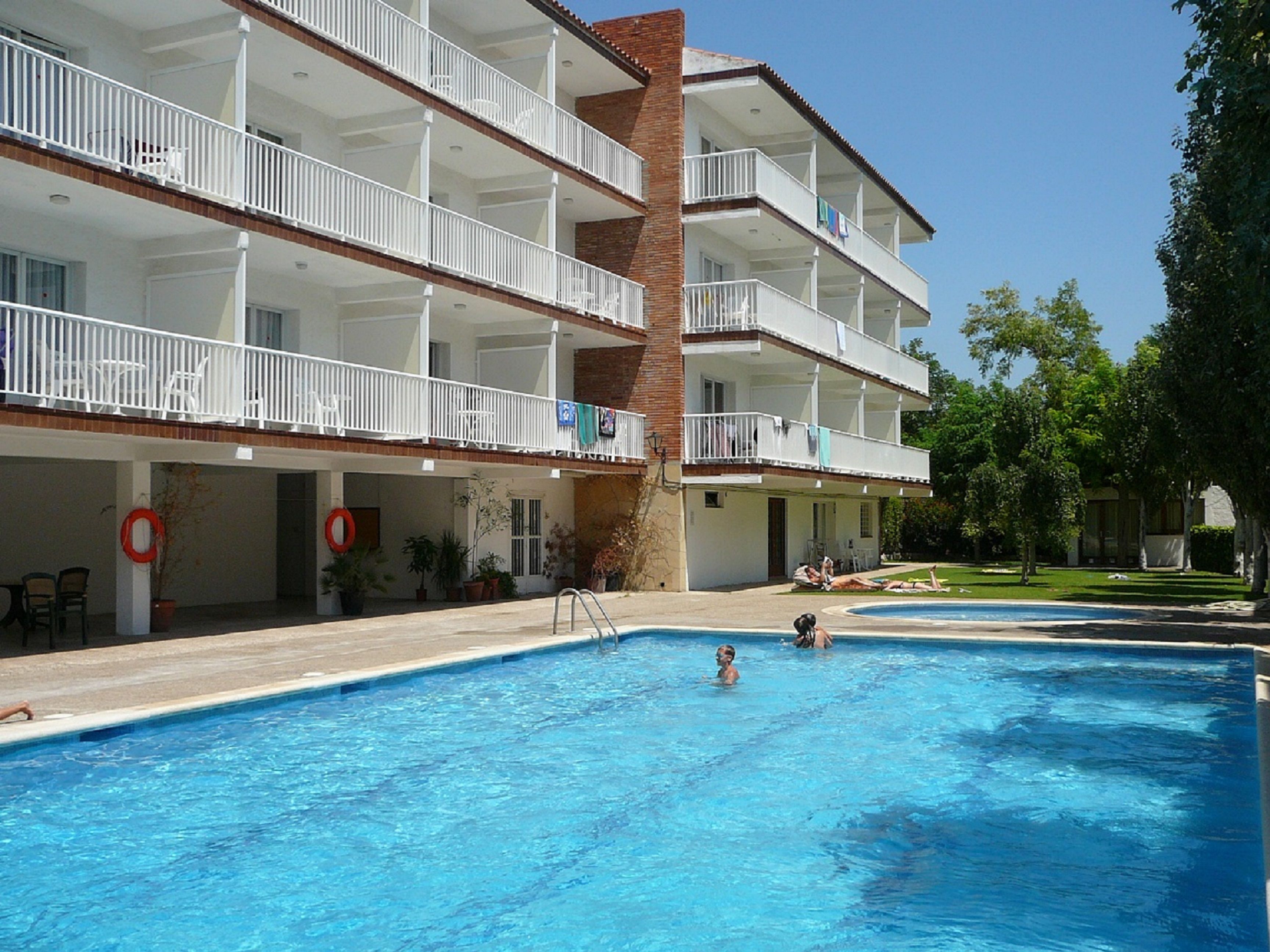 Un hotel amb nombroses galeries, una piscina i zones d'estar a l'aire lliure.
