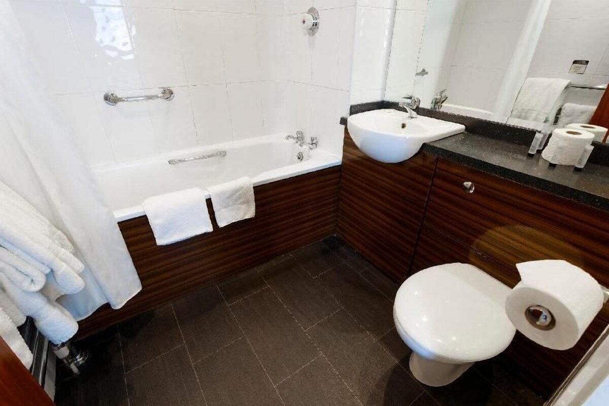 Ein Badezimmer mit Badewanne, Waschbecken, Toilette und Spiegel.