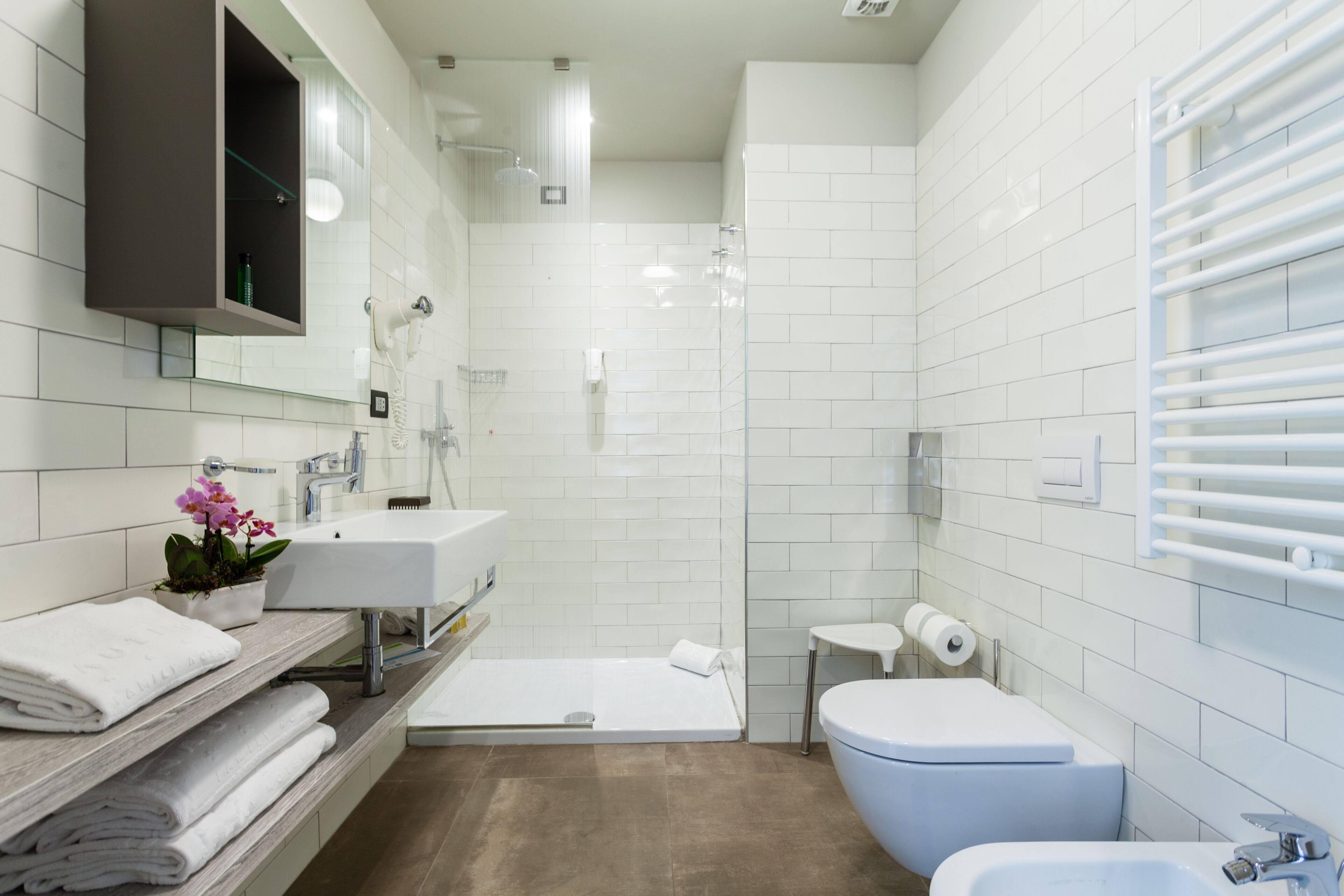 A modern bathroom with a bathtub, toilet, and two sinks.