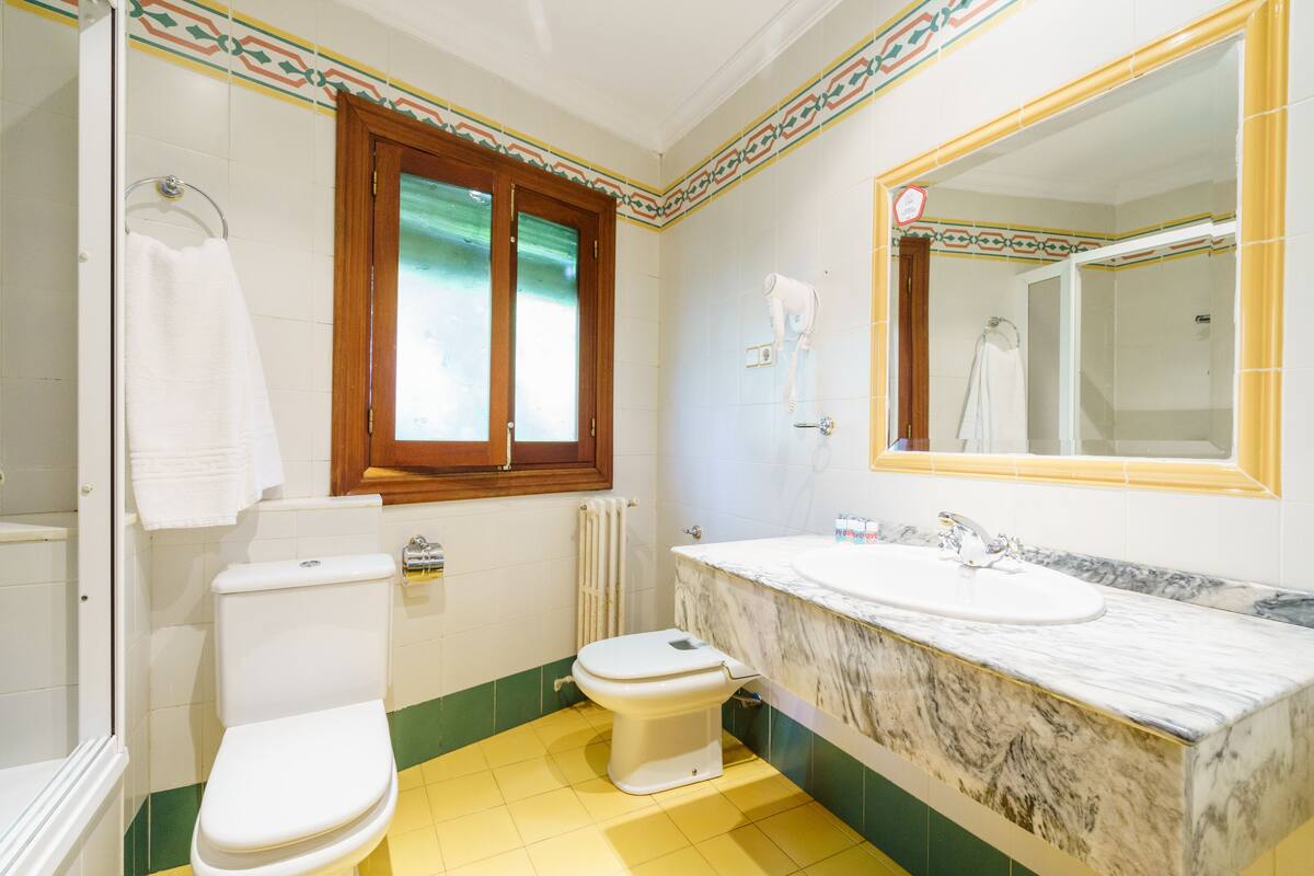 A bathroom with a toilet, sink, and shower.