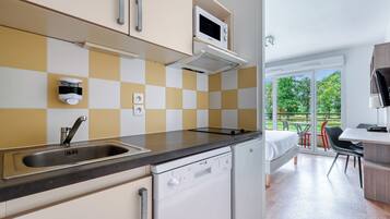 A modern kitchen with a dishwasher, microwave, and a checkered backsplash.