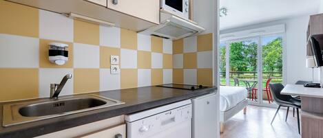 Uma cozinha moderna com lava-louças, micro-ondas e painel de fundo xadrez.