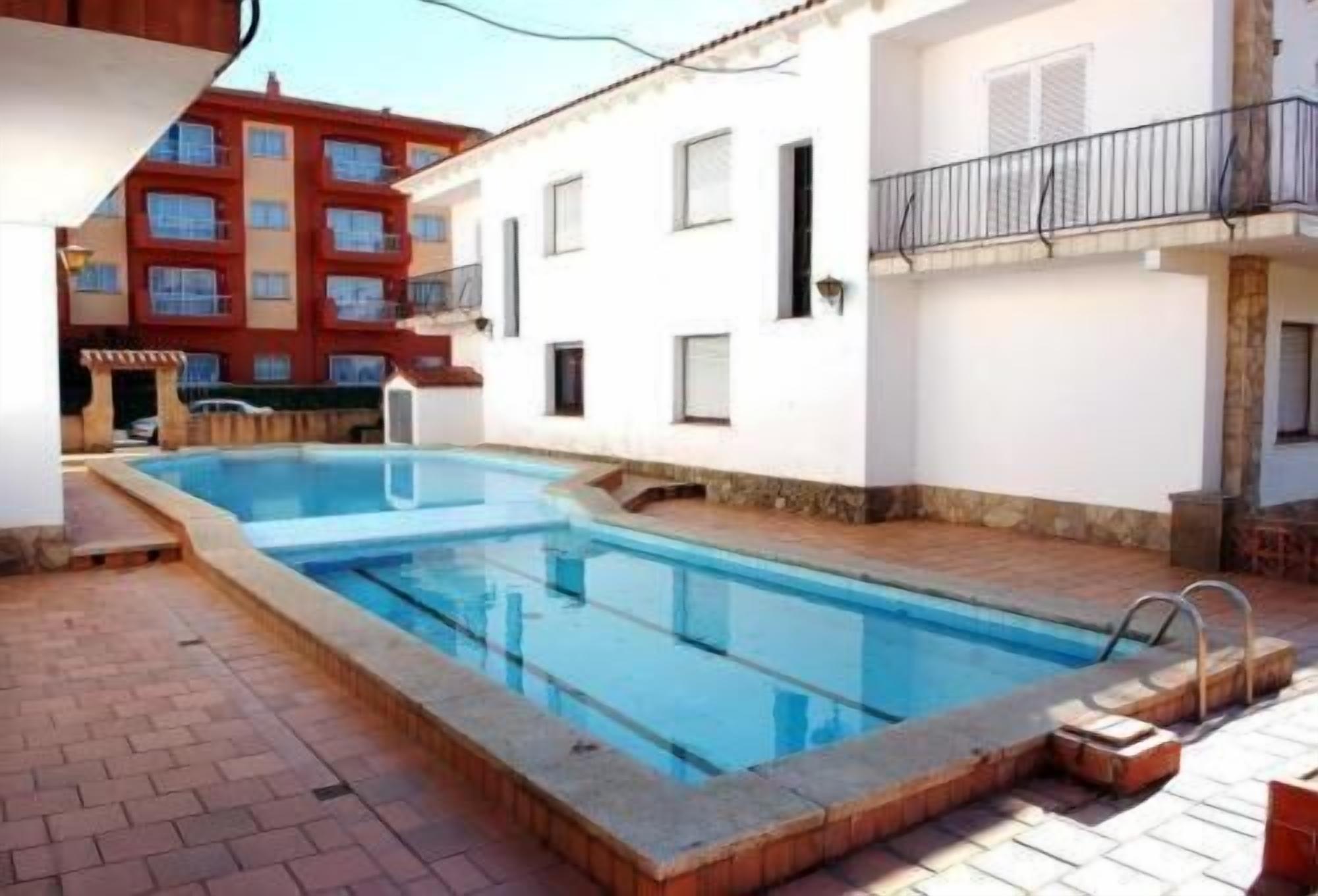 Una piscina al aire libre, tumbonas