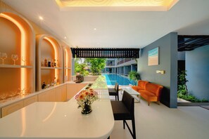 A modern interior with a pool, seating area, and a bar with shelves. - Aree Tara Resort (Krabi)