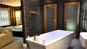 A modern bathroom with a freestanding bathtub, a vanity with a mirror, and a toilet. - Angel Inn Hotel (Pershore)