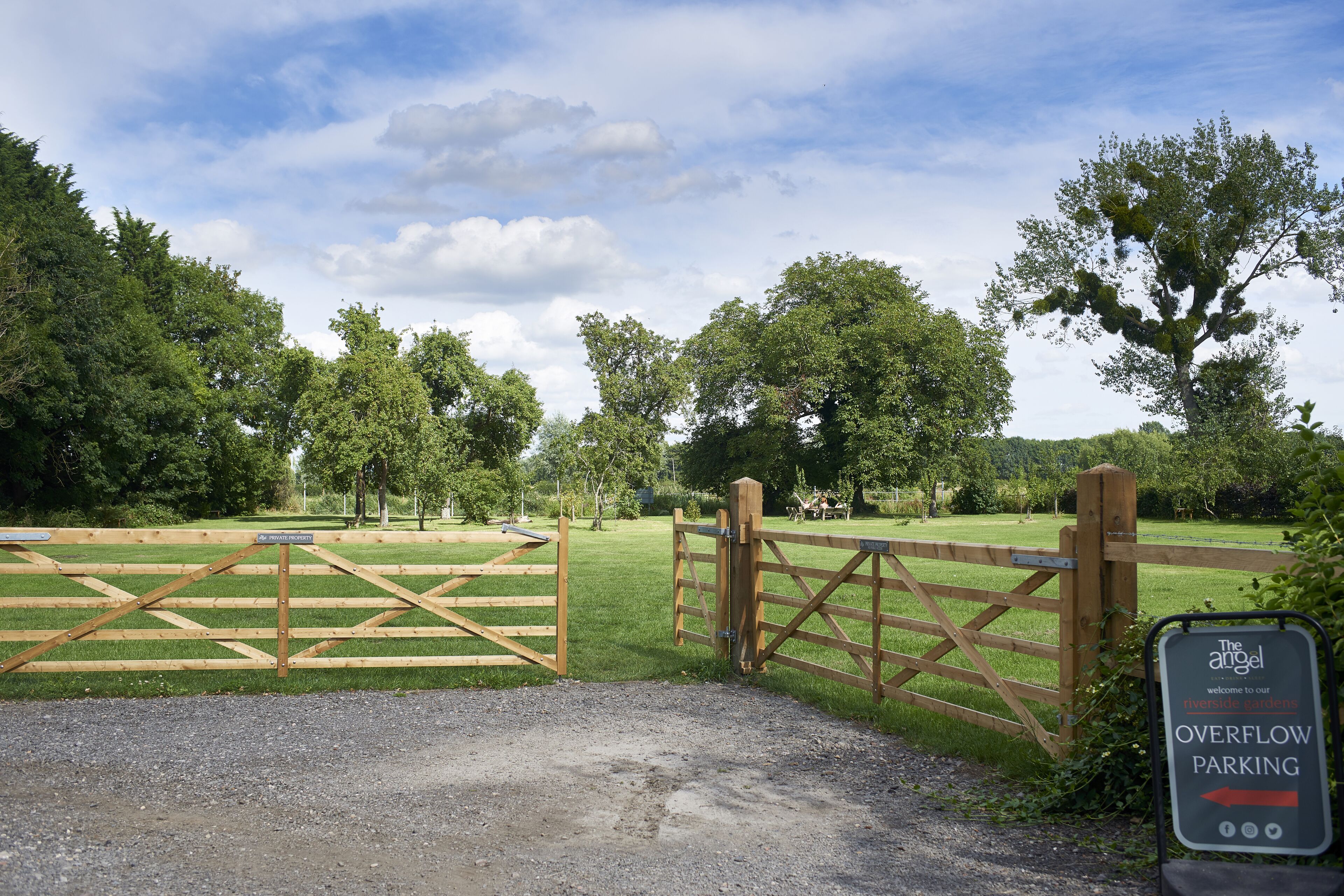 A gated entrance to a park with a sign indicating overflow parking.