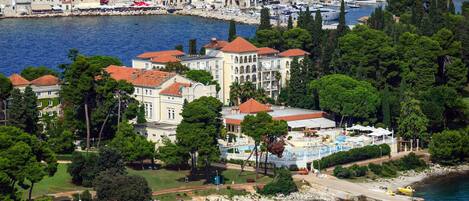 A coastal hotel with multiple buildings, a marina, and a beach area.