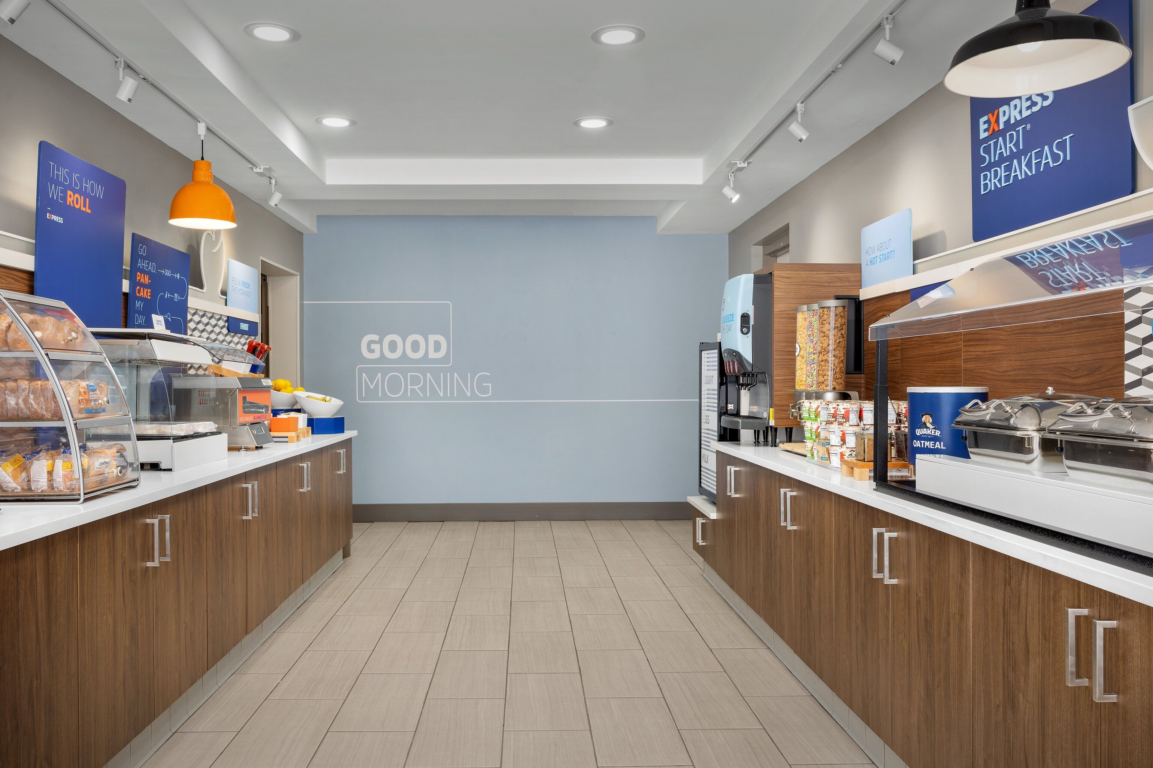 A modern breakfast area with a 'Good Morning' sign, a coffee machine, and various food options.
