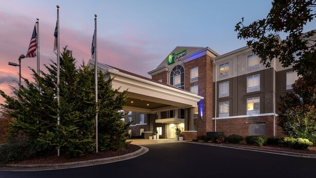 A hotel with a brick facade, a large entrance canopy, and flags.