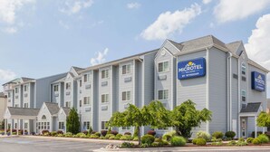A Microtel Inn & Suites building with a row of single-story units, a covered parking area, and landscaped gardens.
