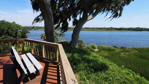 A wooden deck with benches overlooking a lake, surrounded by trees and greenery. - Holiday Inn Express Crystal River by IHG (Crystal River)