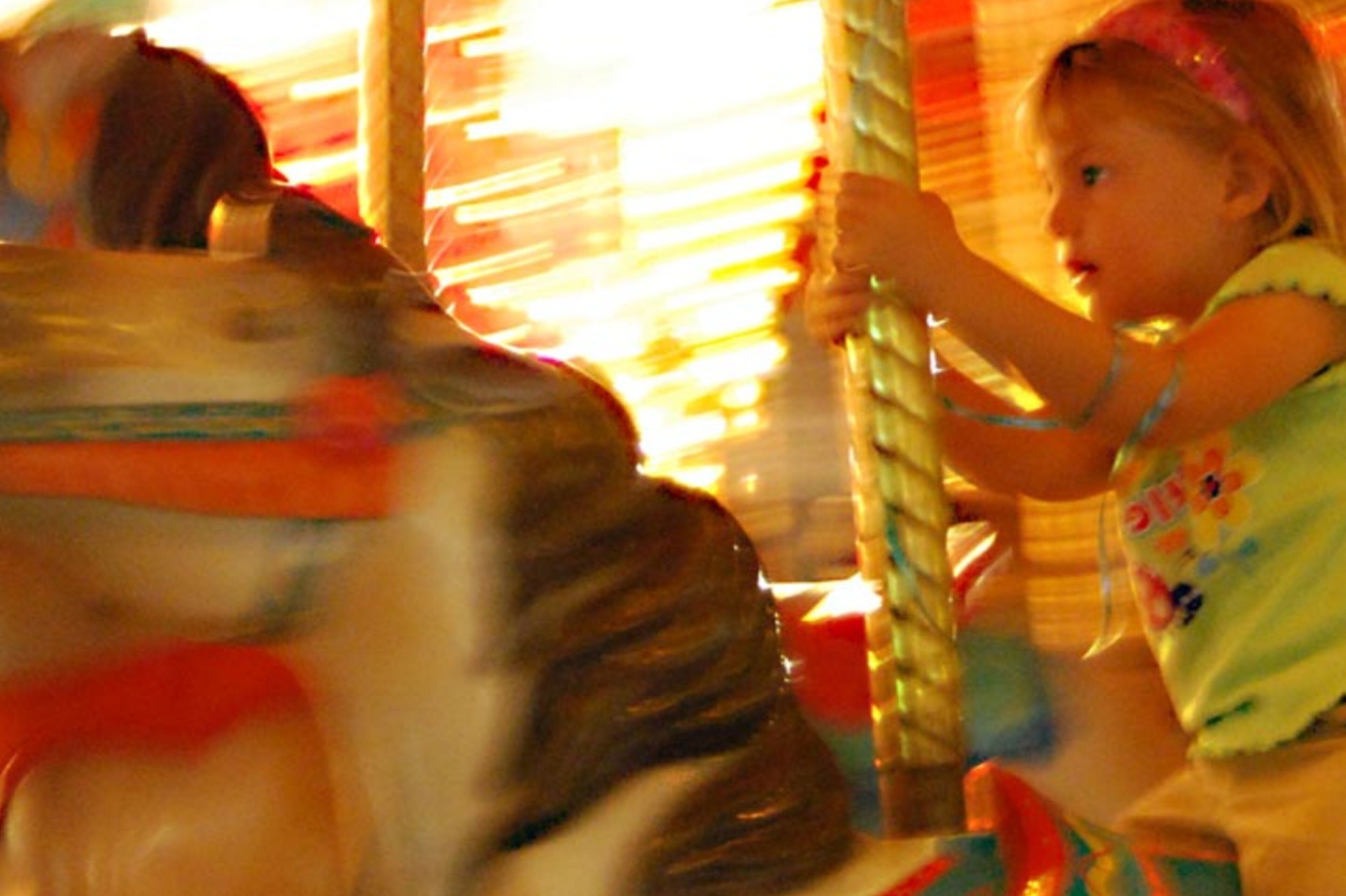 A carousel with a child riding it.
