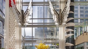 A spacious lobby with a large window, a central floral arrangement, and modern seating.