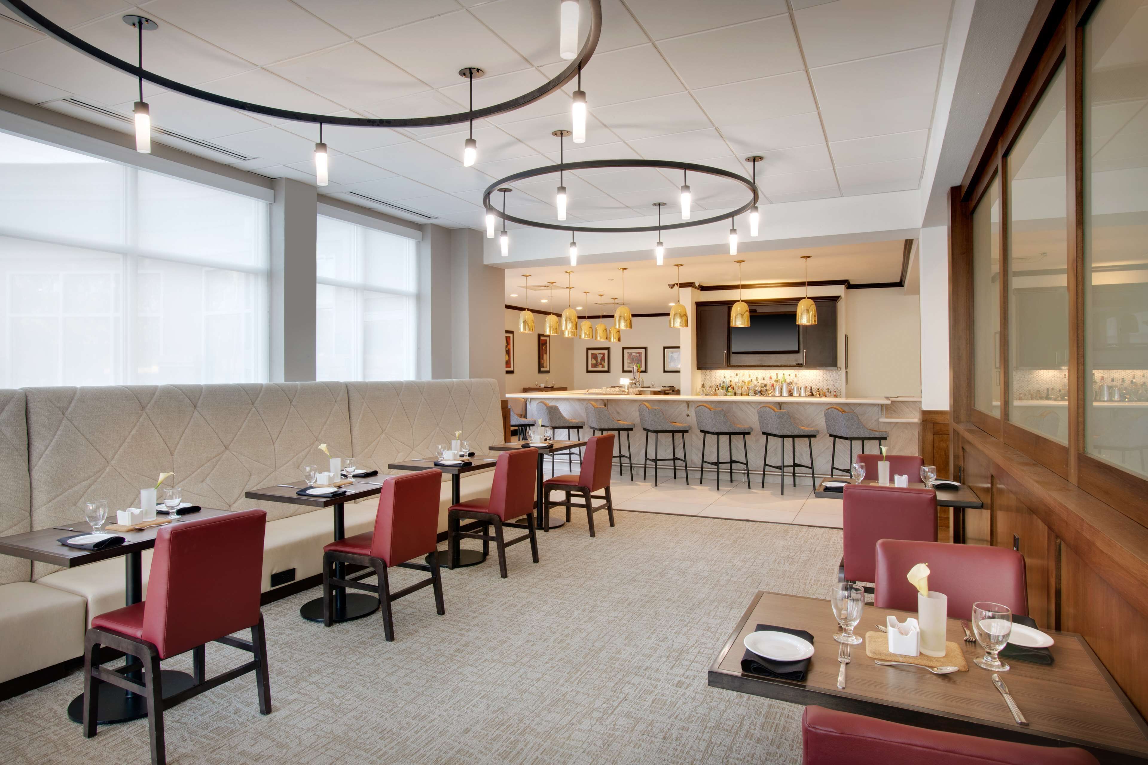 A modern restaurant with booths, high tables, and bar seating.