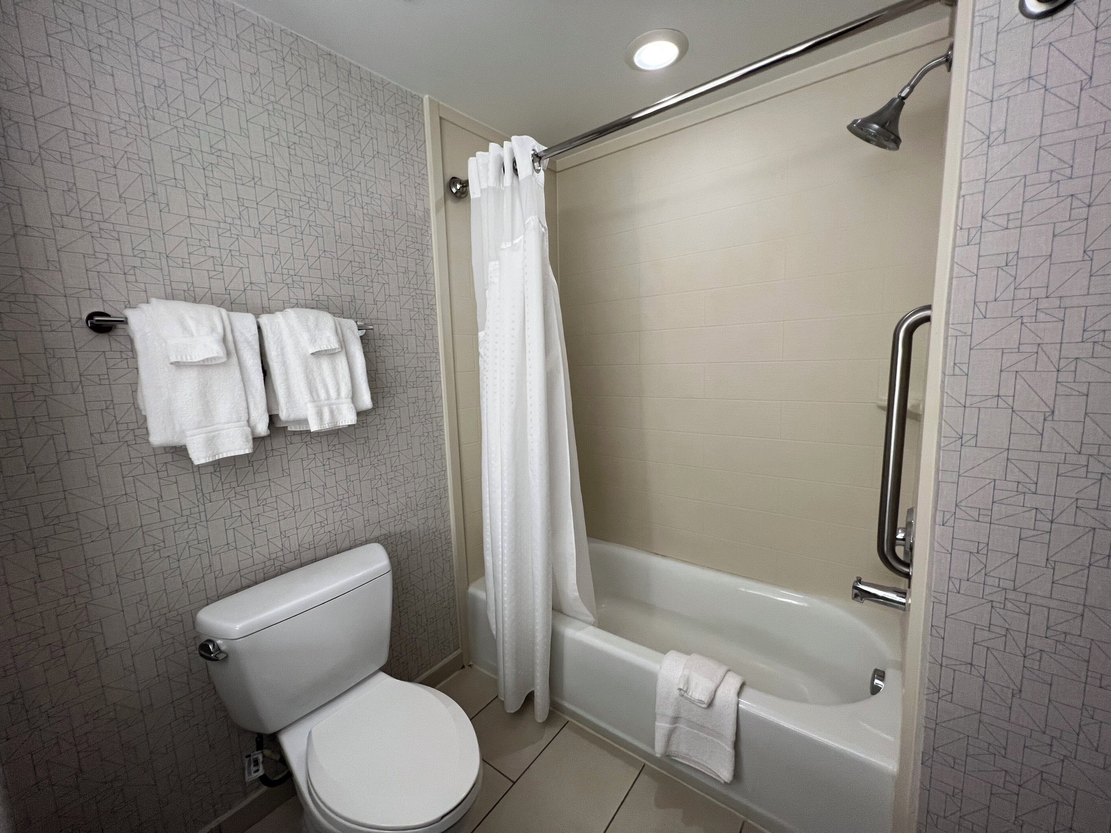 A bathroom with a toilet, a shower with a glass door, and a bathtub.