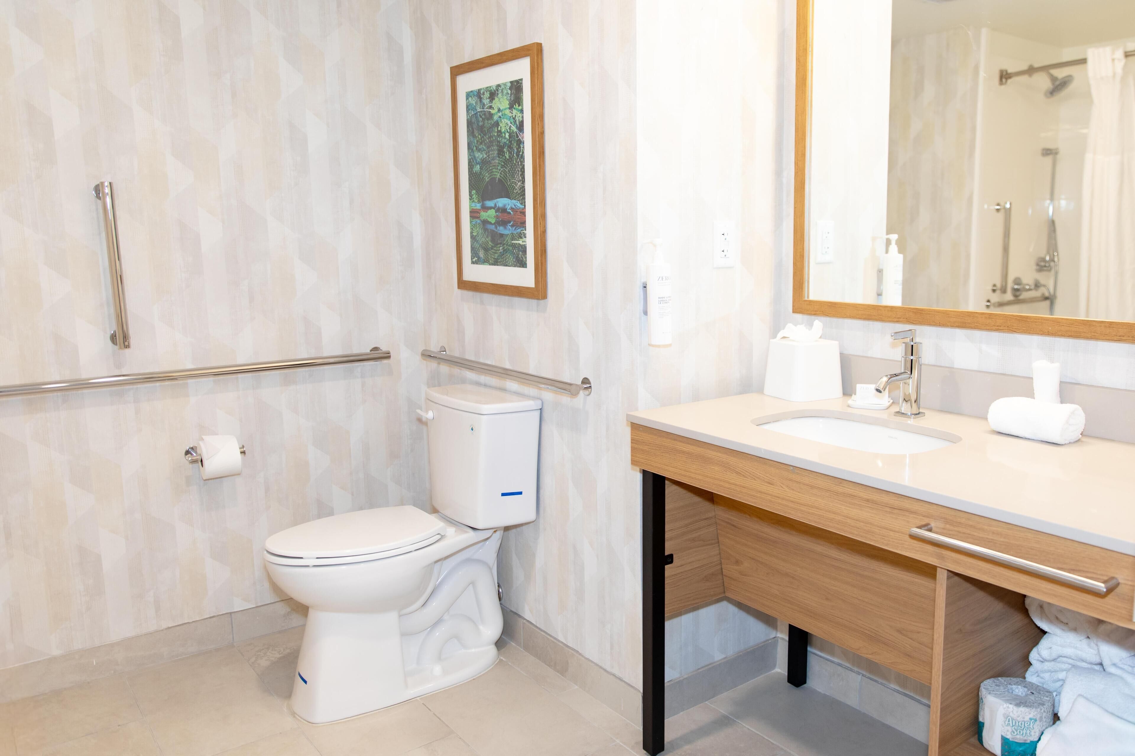 A modern bathroom with a toilet, sink, and mirror.
