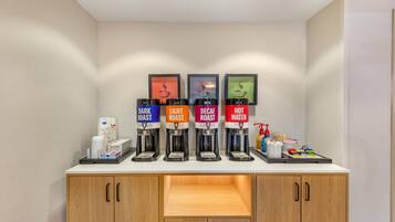 A coffee station with four dispensers labeled DARK ROAST, LIGHT ROAST, DECA ROAST, and HOT WATER.