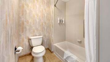 Une salle de bain équipée de toilettes, d’une baignoire et d’une douche.