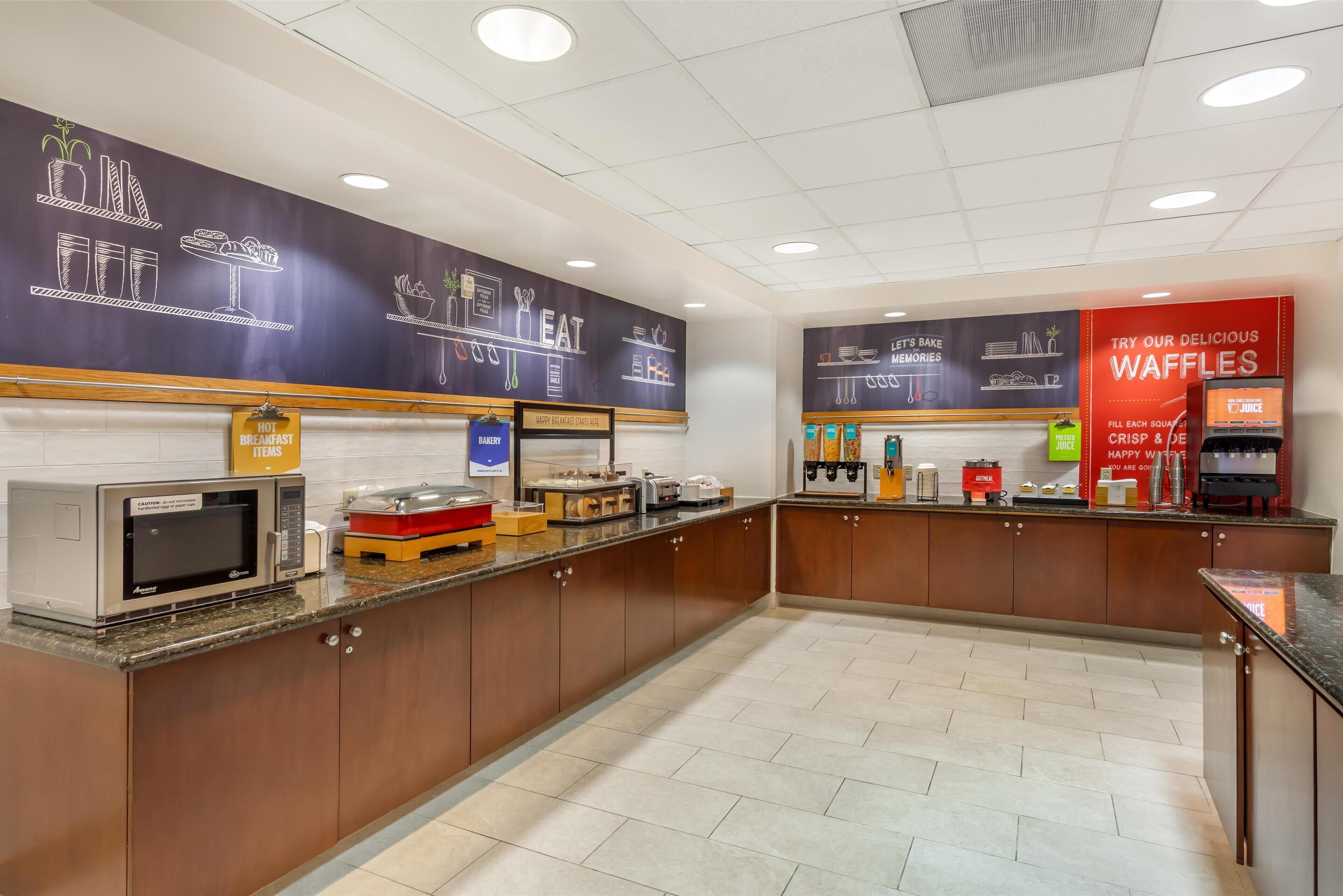 A clean, modern breakfast area with a microwave, toaster, and waffle station.