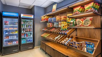 Een presentatie van snacks en drankjes, met gekoelde en ongekoelde opties, zoals chips, snacks en flessen drinken.