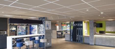 A modern bar area with a counter, stools, and a vending machine.