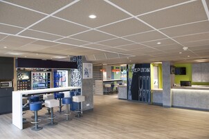 A modern bar area with a counter, stools, and a vending machine.