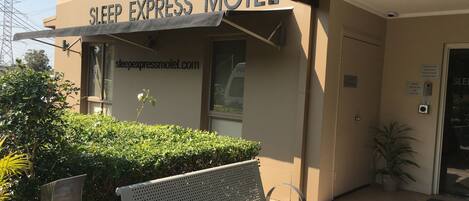 A bench outside a building with a sign reading "SLEEP EXPRESS MOTEL".