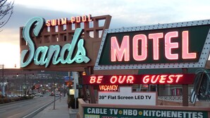 A motel sign with neon lights advertising amenities like a 39" flat screen LED TV, cable TV, HBO, kitchenettes, and high-speed internet. - Sands Motel (St. George)