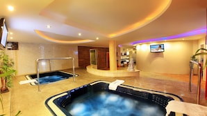 A spa area with two hot tubs, a reception desk, and a television screen. - Palace Hotel Vung Tau (Ho Chi Minh City)