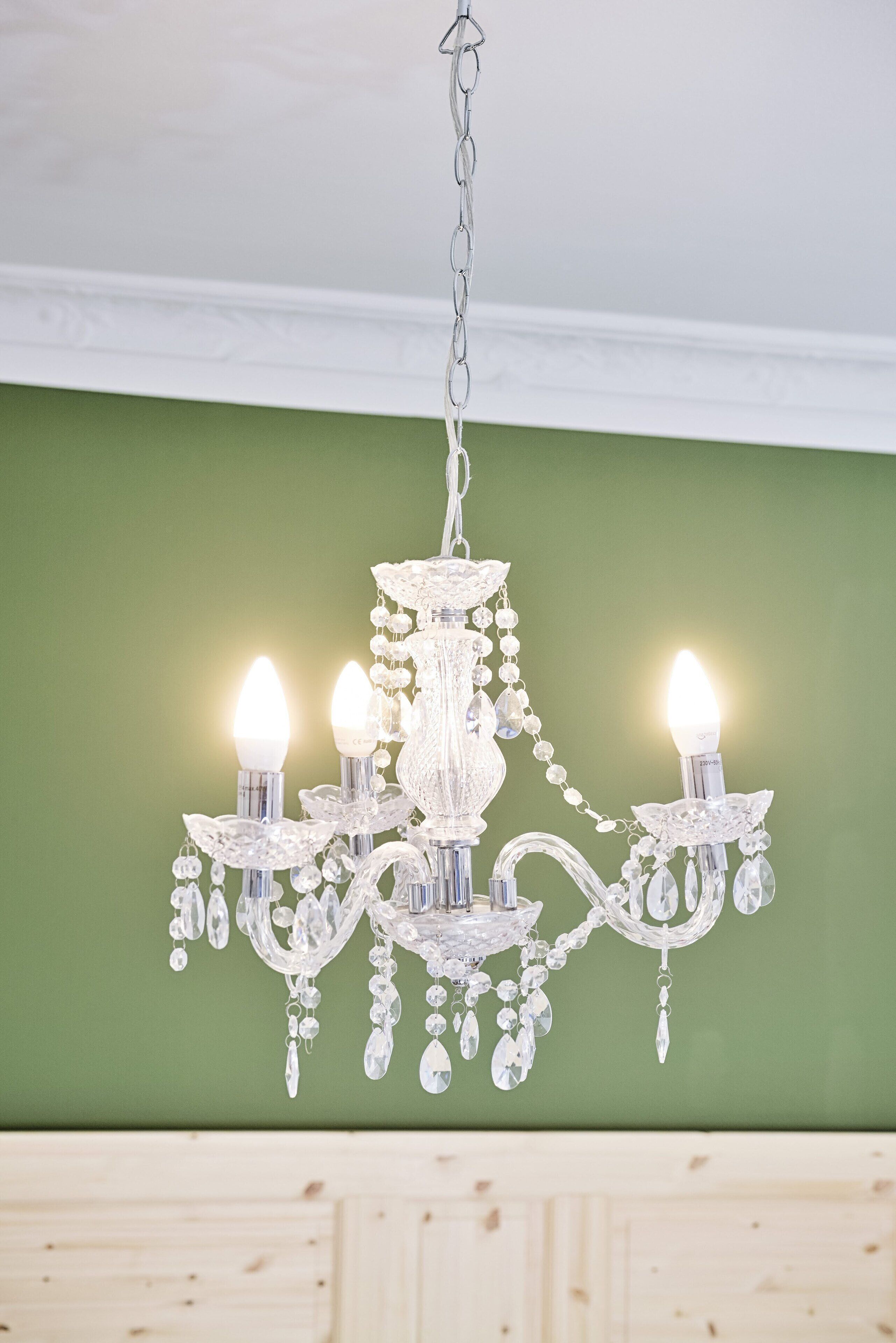 A chandelier with multiple lights and crystal decorations hanging from a chain.
