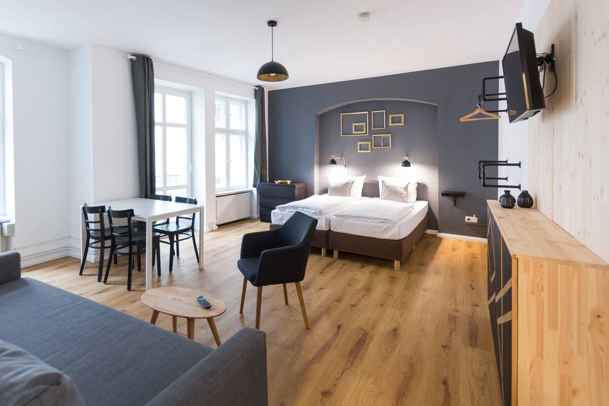 Een moderne hotelkamer met een bed, nachtkastjes, een bureau en een bank.