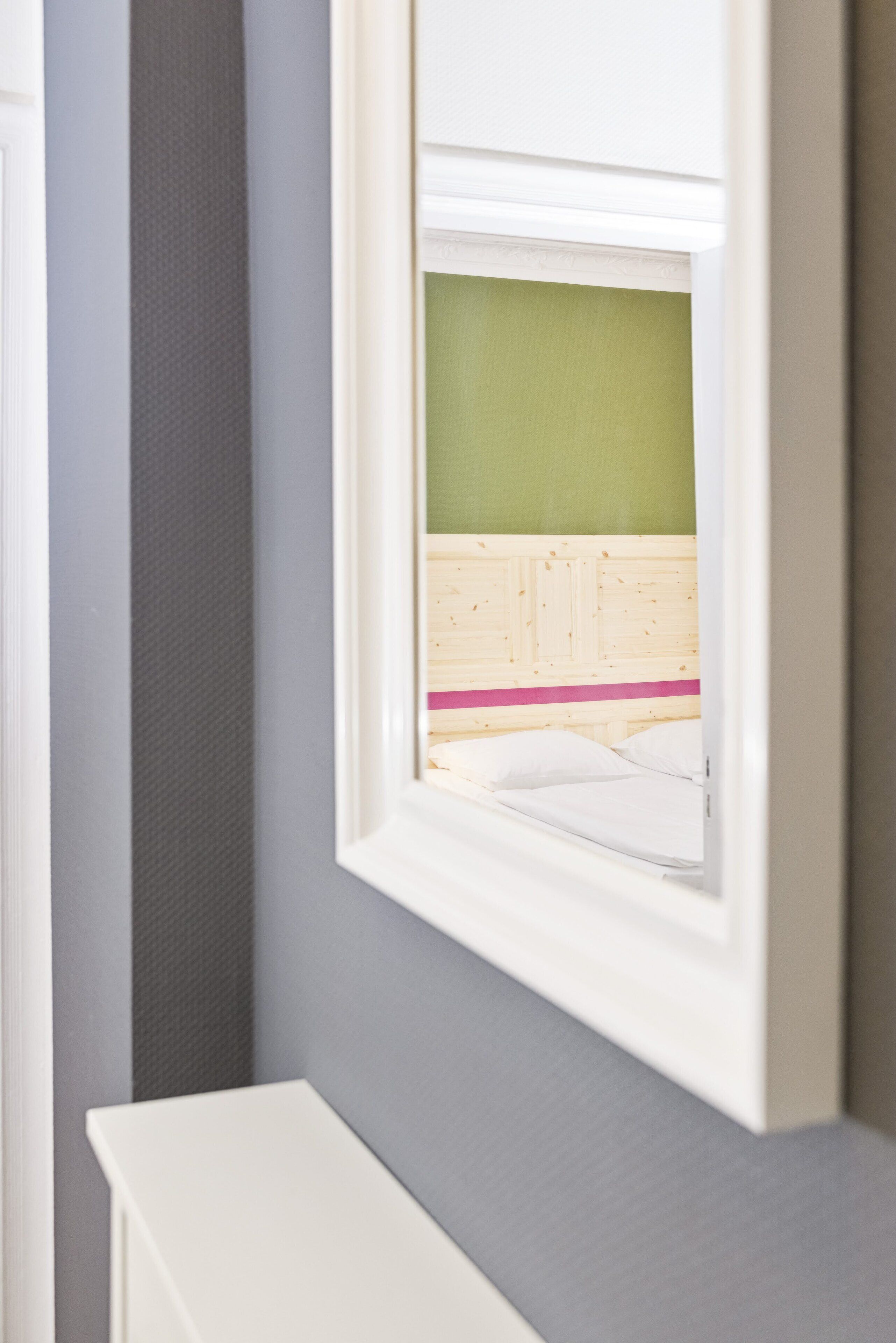 A room with a bed, a window, and a white dresser.
