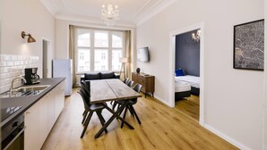 A modern apartment with a kitchen, dining area, and a bedroom.
