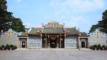 Um templo chinês tradicional com arquitetura elaborada, um amplo pátio aberto e estátuas.