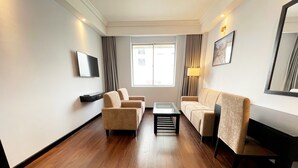 Un salon moderne comprenant un canapé, une table basse et un téléviseur fixé au mur.