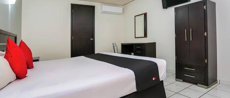 Une chambre d’hôtel équipée d’un lit, d’une armoire, d’un téléviseur et d’un appareil de climatisation.
