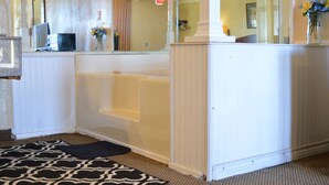 A bathroom with a bathtub, a mirror, a sink, and a patterned rug. - Knights Inn Greenville, TX (Greenville)
