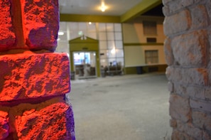 A brick wall with a window in the foreground and a building interior in the background. - Knights Inn Greenville, TX (Greenville)
