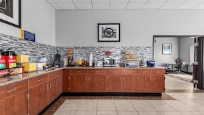 A modern kitchen with a central island, stainless steel appliances, and a tiled backsplash.